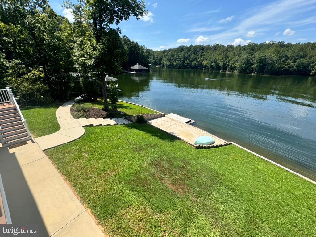 8 Elnor Road Bumpass, VA 23024 - Photo 10 of 13 Serene lakeside retreat with lush greenery.