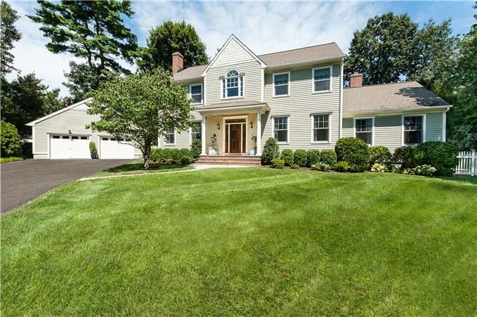 a front view of a house with a yard and green space