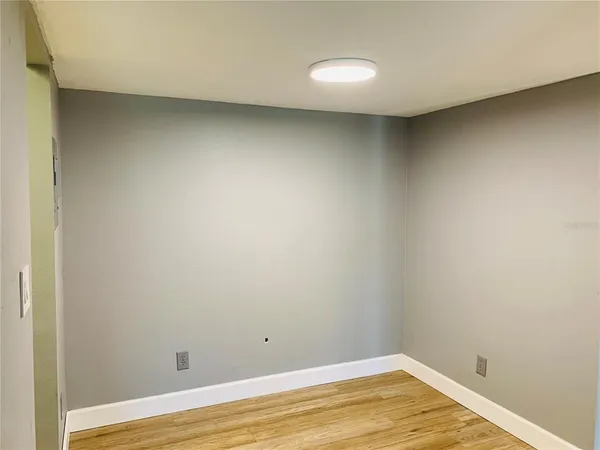 a view of an empty room with wooden floor