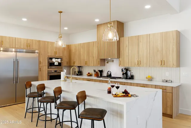 a kitchen with stainless steel appliances kitchen island granite countertop a sink and refrigerator
