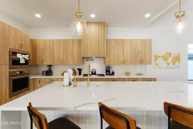 a kitchen with a table chairs microwave and cabinets