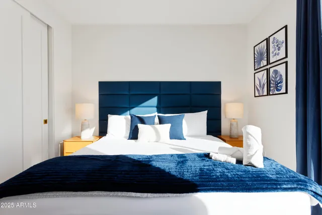 a bedroom with a large bed and a potted plant