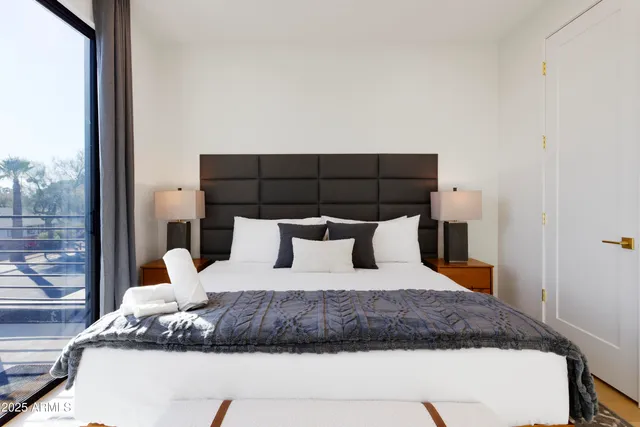 a large bed sitting in a bedroom next to a window