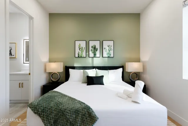 a bedroom with a bed and a painting on the wall