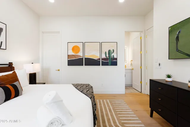 a bedroom with a bed and a flat tv screen on dresser