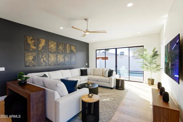 a living room with furniture a flat screen tv and a large window