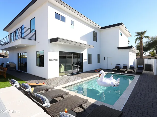 a view of a house with swimming pool and sitting area