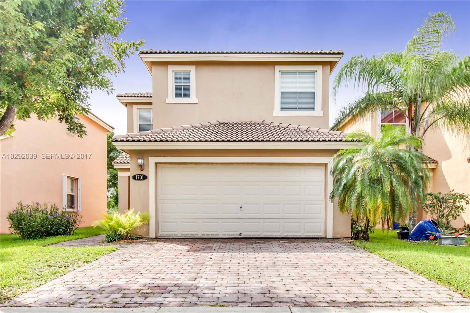 1701 Southeast 20th Road Homestead, FL 33035 - Photo 3 of 42 a front view of a house with a garden and palm trees