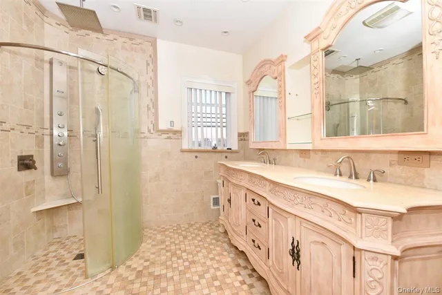 a bathroom with double vanity and a shower