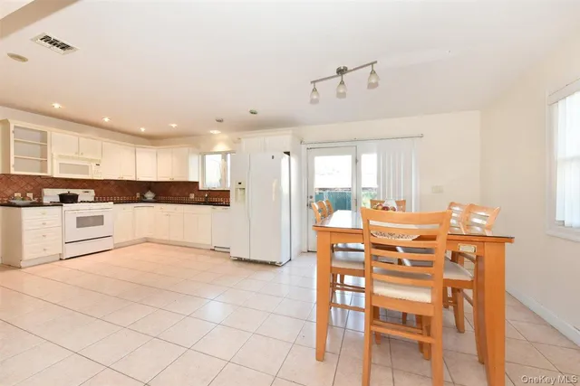 a view of kitchen with cabinets and refrigerator