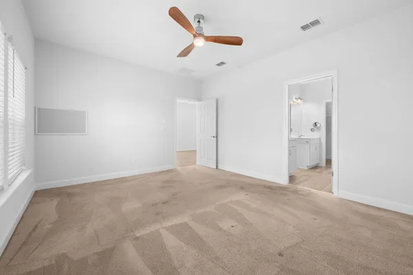 an empty room with a ceiling fan and window