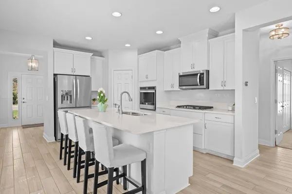 a kitchen with kitchen island granite countertop a white cabinets and stainless steel appliances