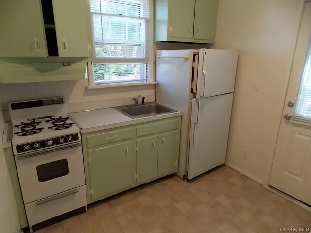 a kitchen with a stove cabinets and a refrigerator