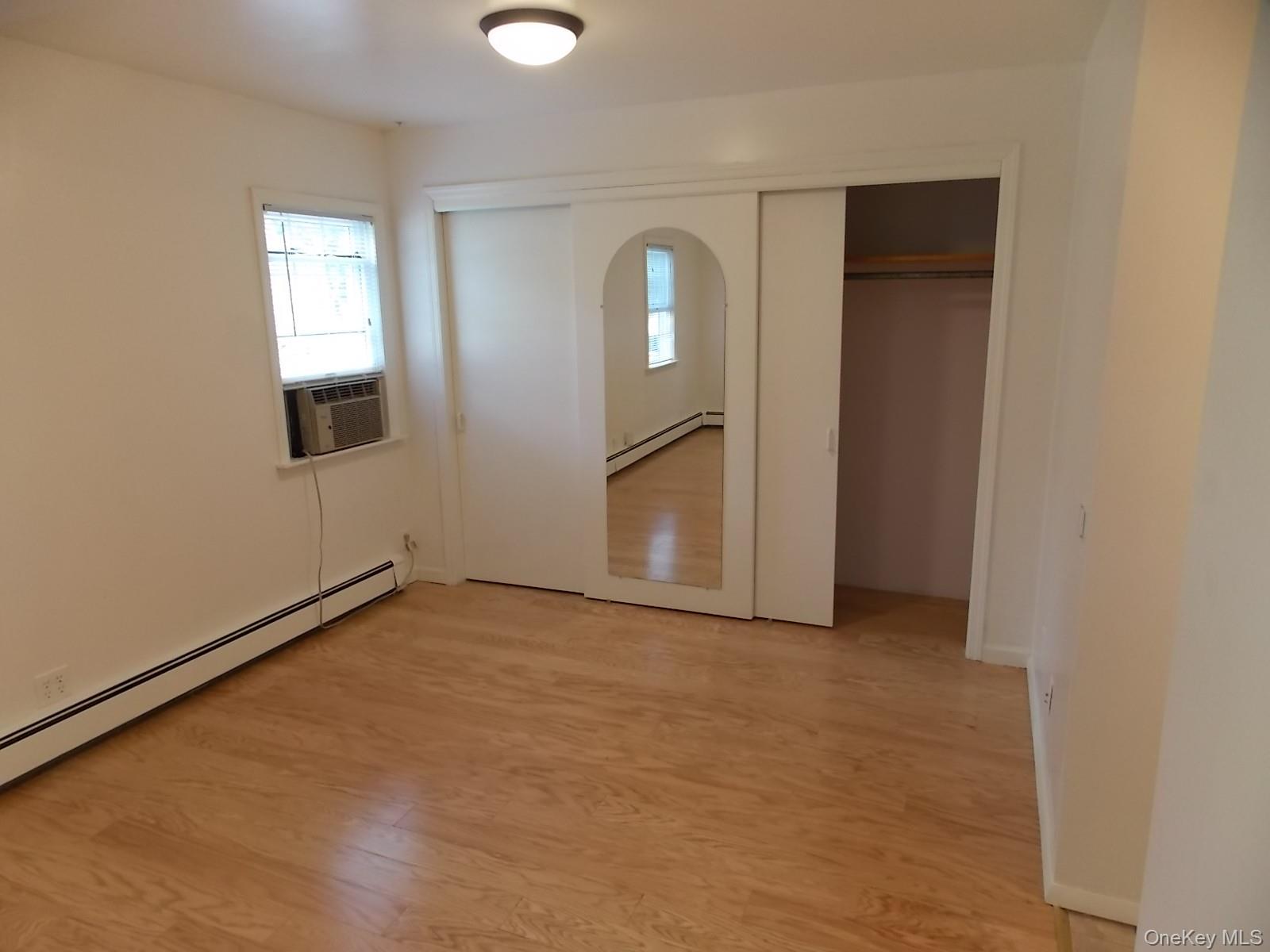 111 Lakeside Trail, Unit A Ridge, NY 11961 - Photo 5 of 7 an empty room with windows and closet