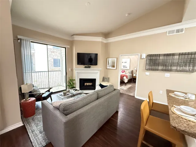 a living room with furniture a fireplace and a flat screen tv