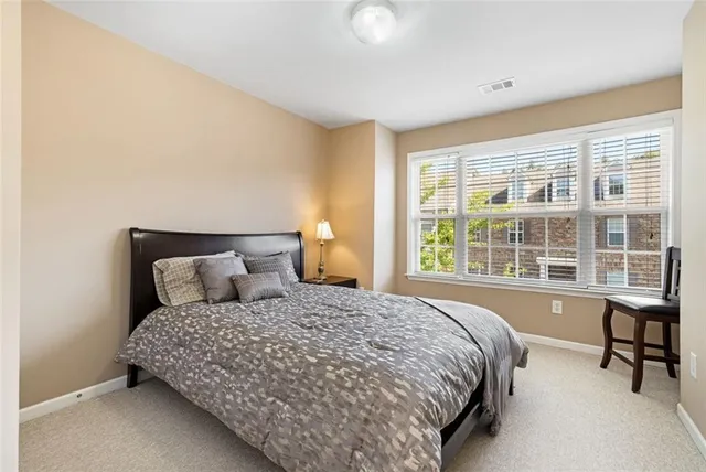 a large bed sitting in a bedroom next to a window