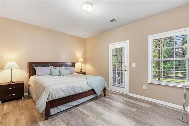 a bedroom with a bed lamp and a large window