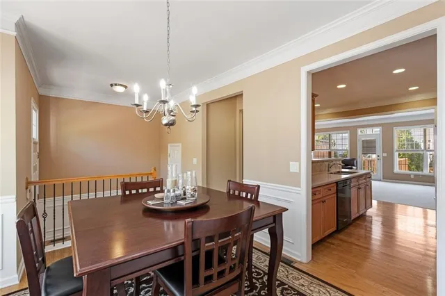 a view of a dining room with furniture a chandelier and wooden floor
