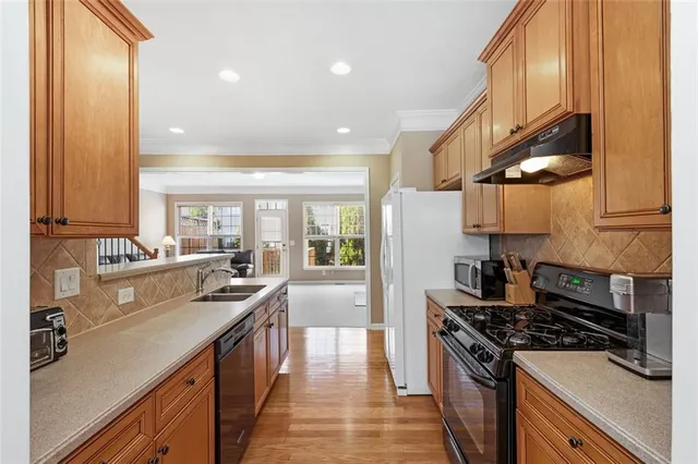 a kitchen with stainless steel appliances a sink stove and cabinets