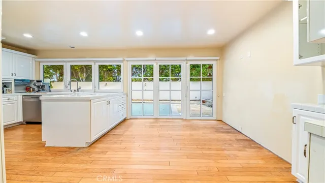 a large white kitchen with sink and cabinets