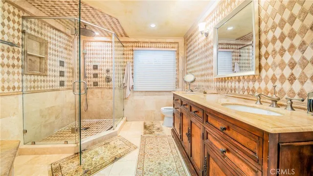 a spacious bathroom with a granite countertop sink and a shower