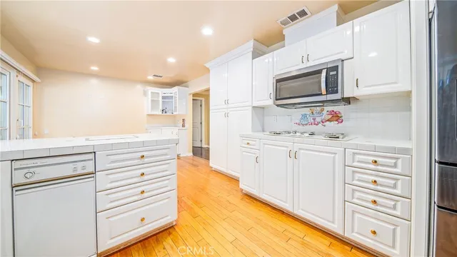 a kitchen with stainless steel appliances a stove microwave and cabinets