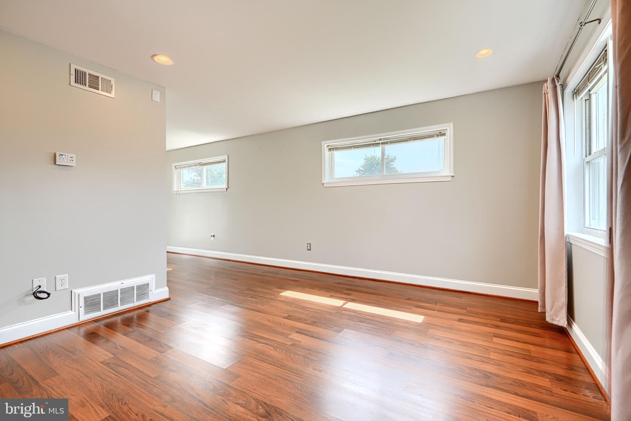 815 Lannerton Road Baltimore, MD 21220 - Photo 8 of 41 an empty room with wooden floor and windows