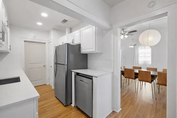 a kitchen with stainless steel appliances a refrigerator and wooden floor