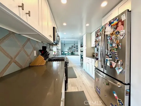 a kitchen with stainless steel appliances granite countertop a sink a stove and a wooden cabinets