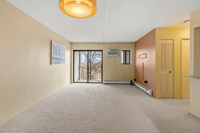 an empty room with windows and mirror