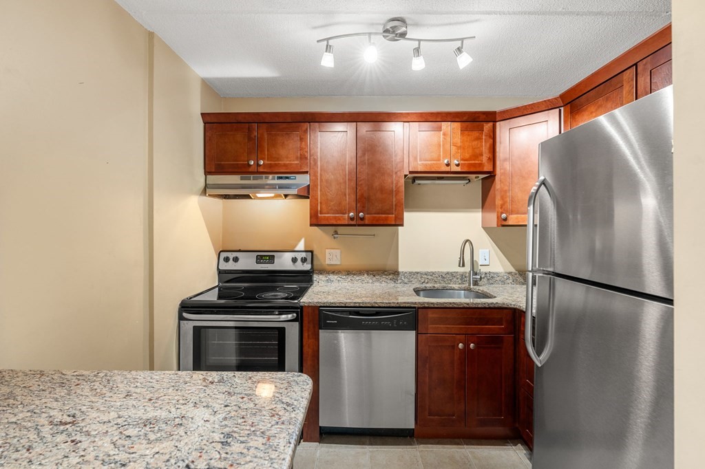 159 Franklin Street, Unit D2 Stoneham, MA 02180 - Photo 6 of 27 a kitchen with stainless steel appliances granite countertop a refrigerator a stove and a refrigerator