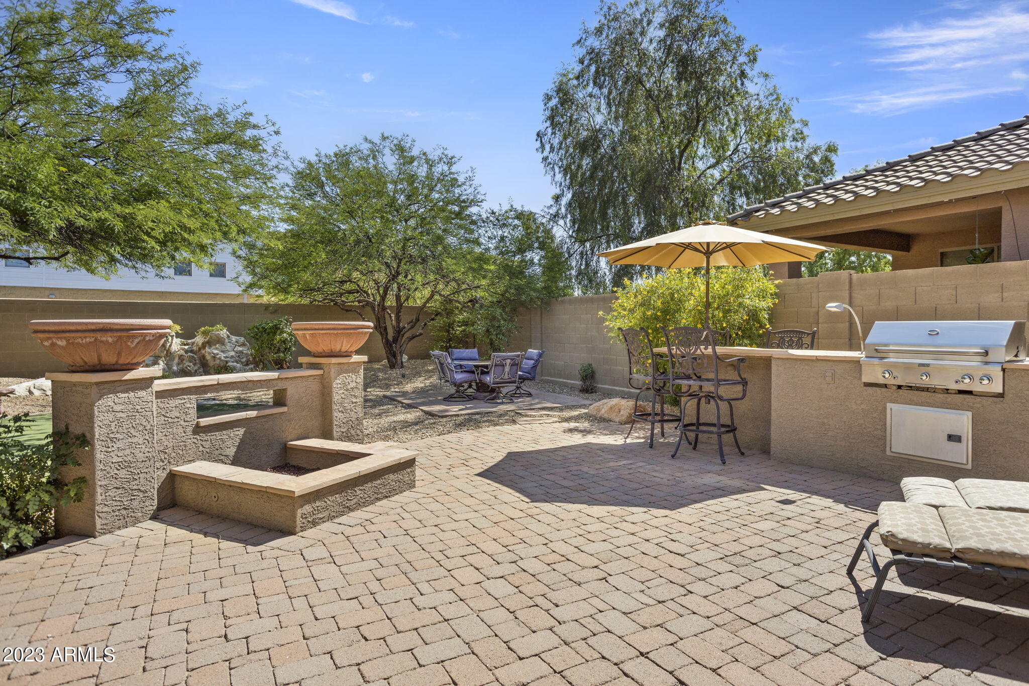 3739 West Memorial Drive Anthem, AZ 85086 - Photo 23 of 23 a view of a patio with table and chairs potted plants and a palm tree