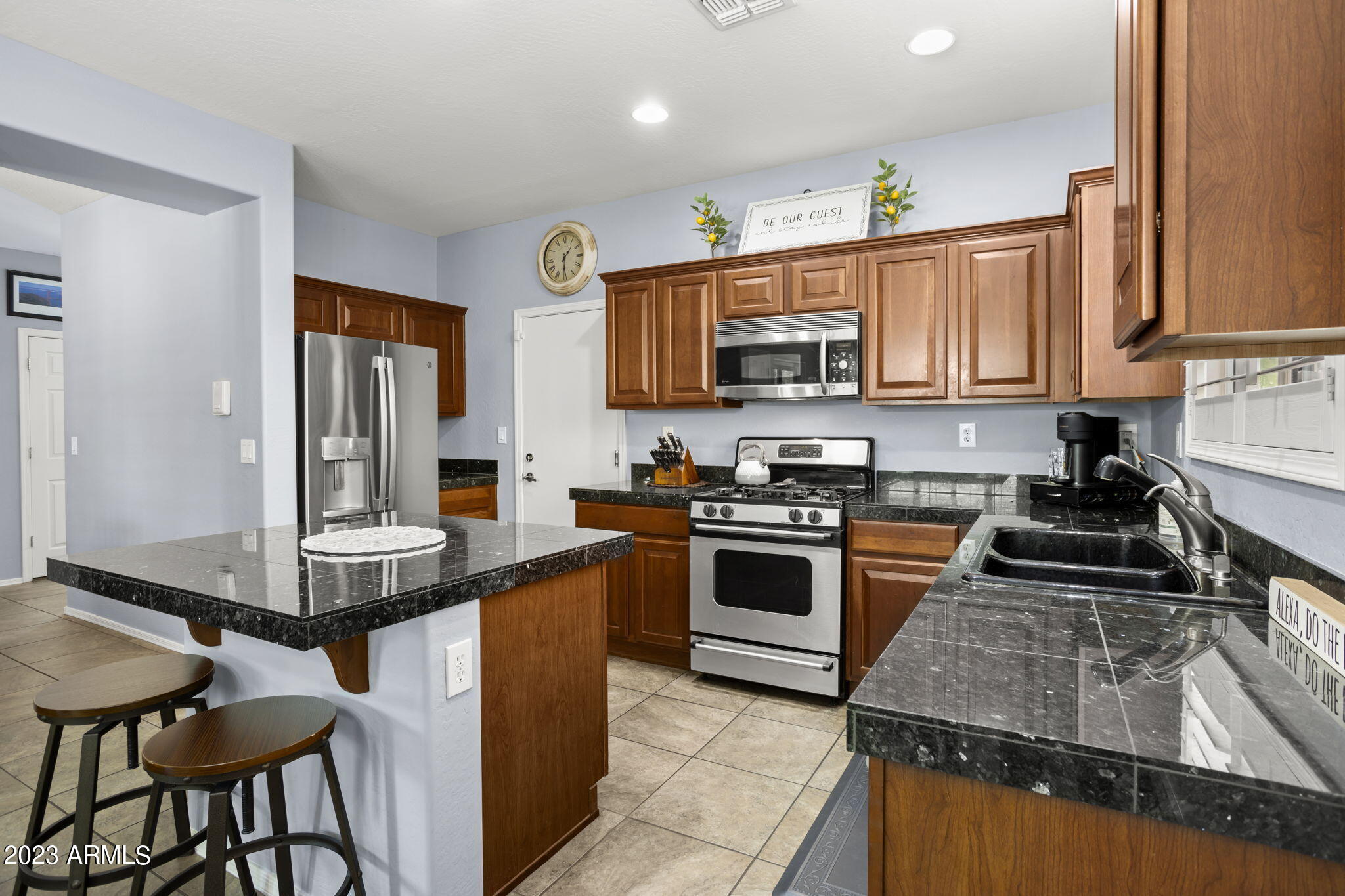 3739 West Memorial Drive Anthem, AZ 85086 - Photo 7 of 23 a kitchen with kitchen island granite countertop a stove top oven a sink dishwasher and cabinets with wooden floor