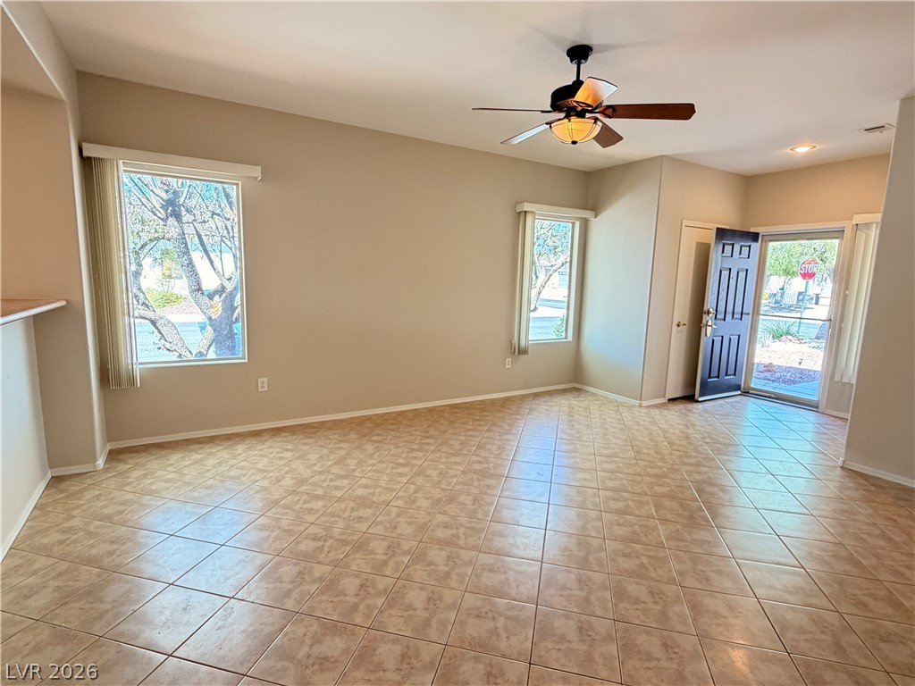 2523 Romanza Road Henderson, NV 89052 - Photo 18 of 24 A well-lit living area features tiled flooring and ample natural light from multiple windows and a glass-paneled entry.