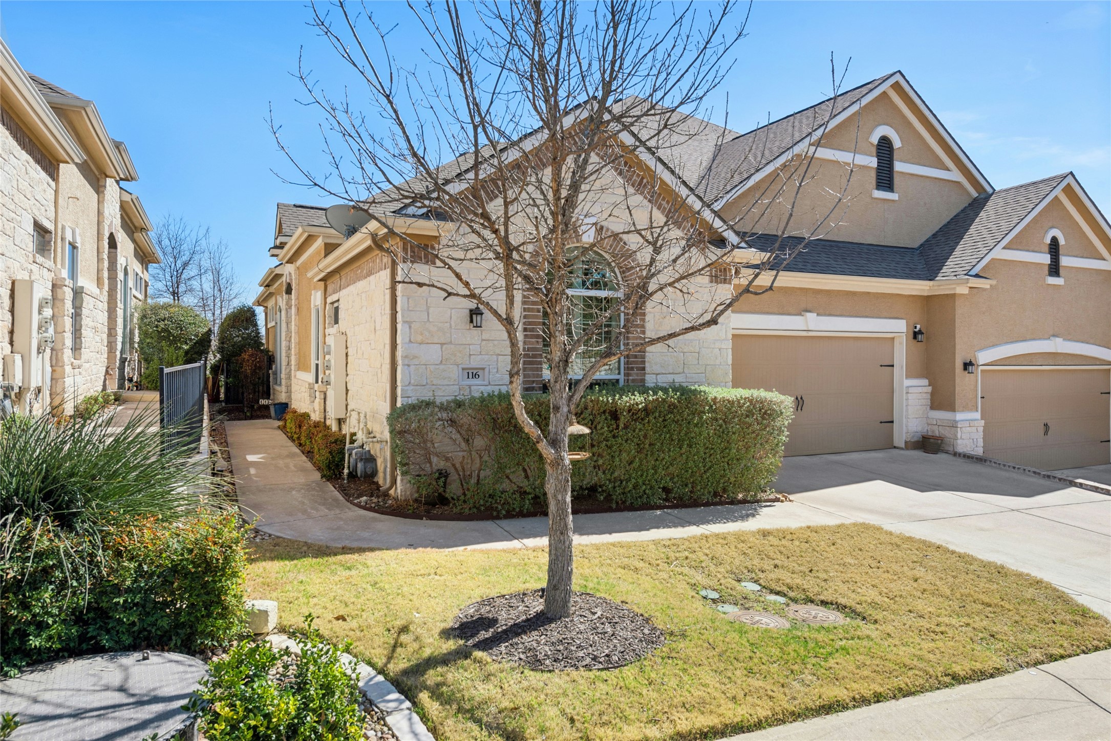116 Evolutions Path Lakeway, TX 78738 - Photo 2 of 34 View of front of house featuring stone siding, driveway, a front lawn, an attached garage, and a shingled roof