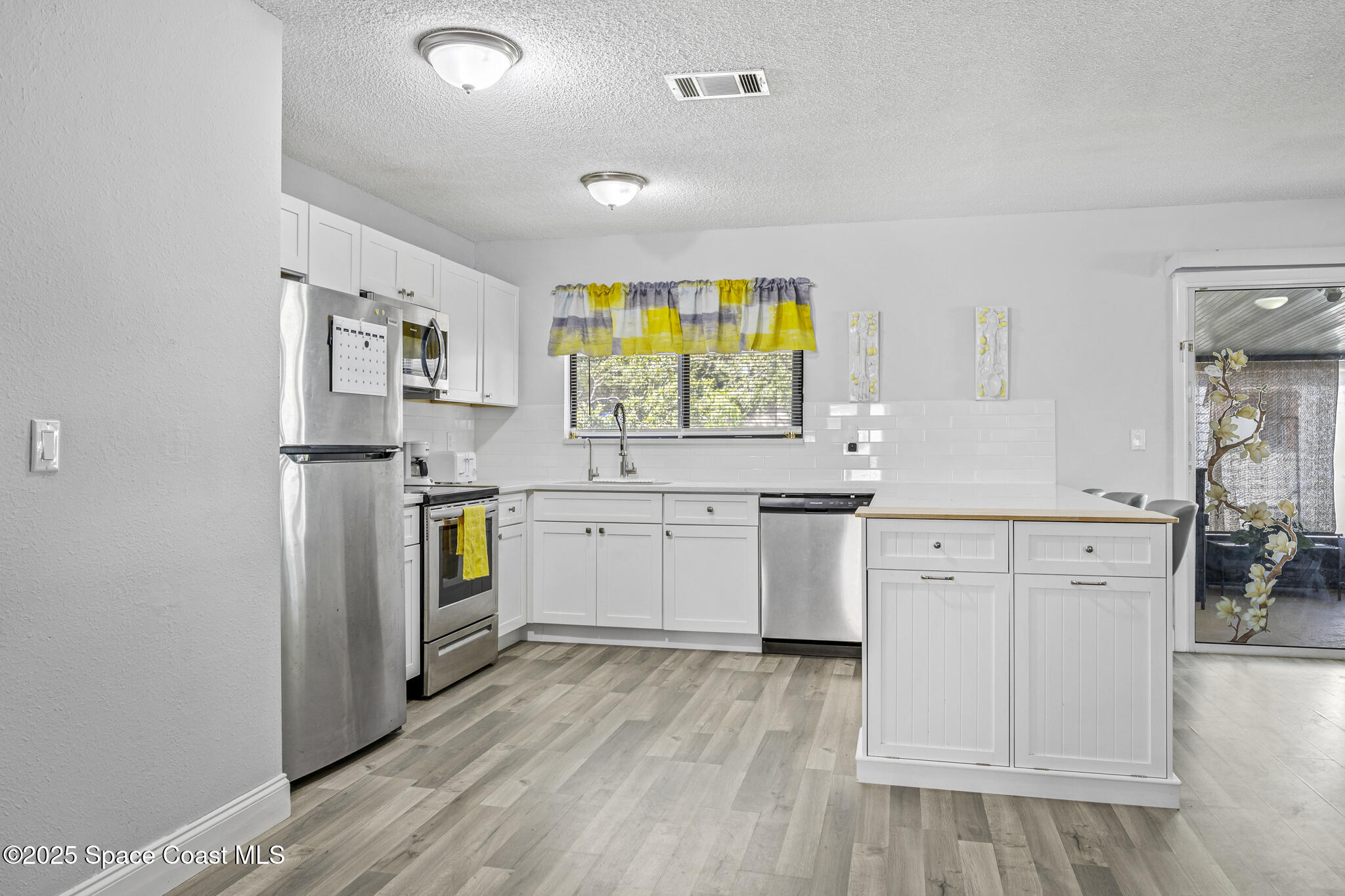 797 Tooley Road Southwest Palm Bay, FL 32908 - Photo 21 of 38 a kitchen with a refrigerator and a stove top oven