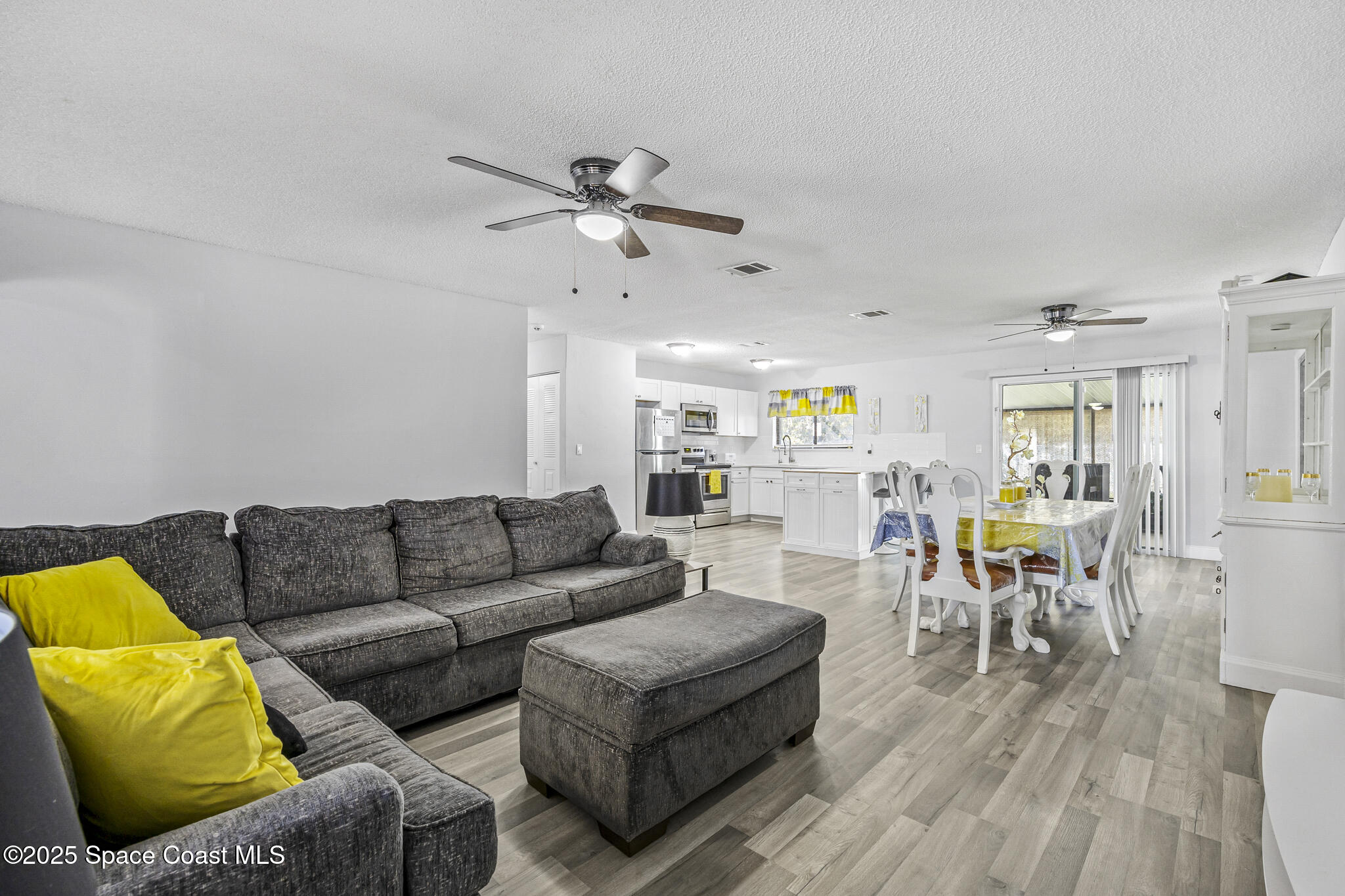 797 Tooley Road Southwest Palm Bay, FL 32908 - Photo 3 of 38 a living room with furniture kitchen view and a wooden floor