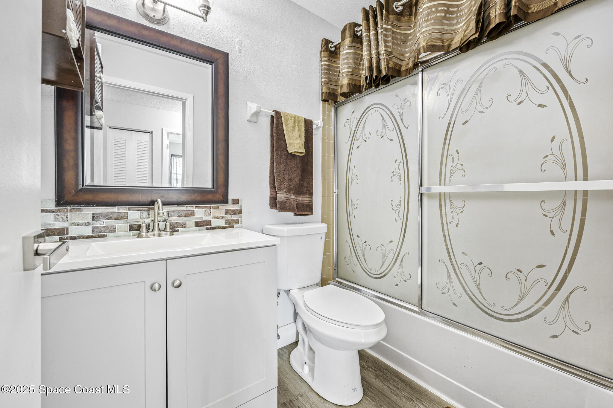 797 Tooley Road Southwest Palm Bay, FL 32908 - Photo 34 of 38 a bathroom with a granite countertop toilet sink and mirror