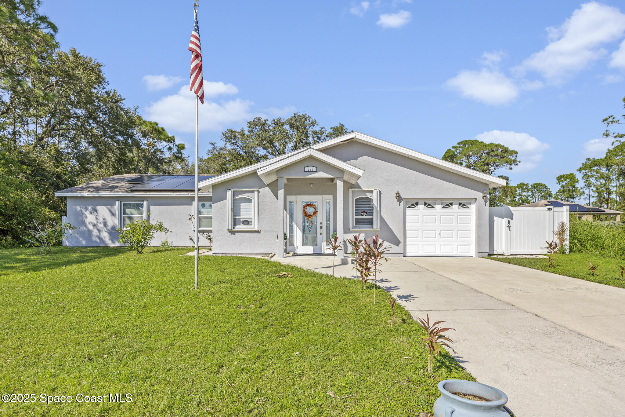 797 Tooley Road Southwest Palm Bay, FL 32908 - Photo 6 of 38 a front view of a house with a garden and yard