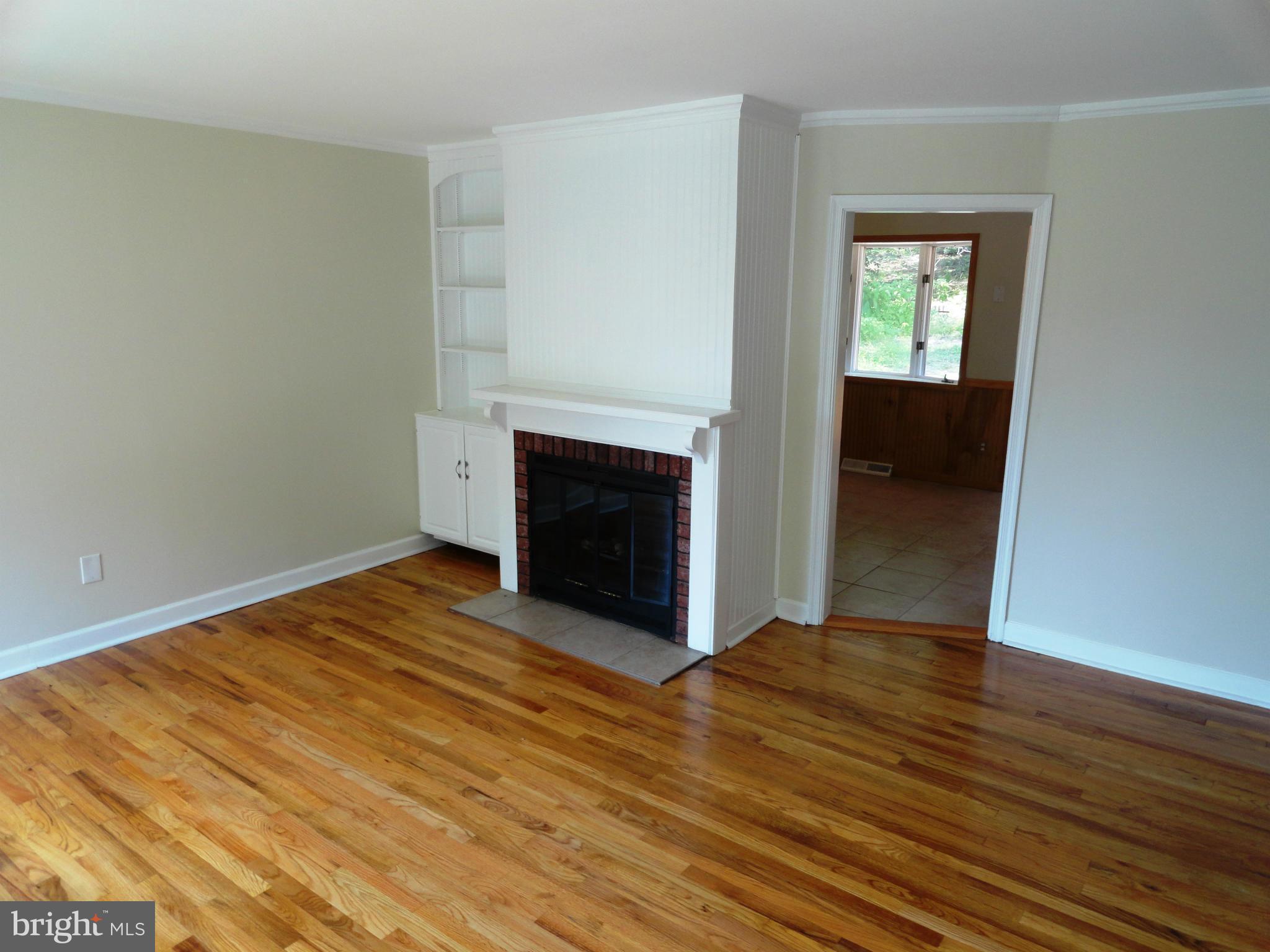 1614 Weyburn Road Baltimore, MD 21237 - Photo 5 of 25 wooden floor fireplace and natural light in room