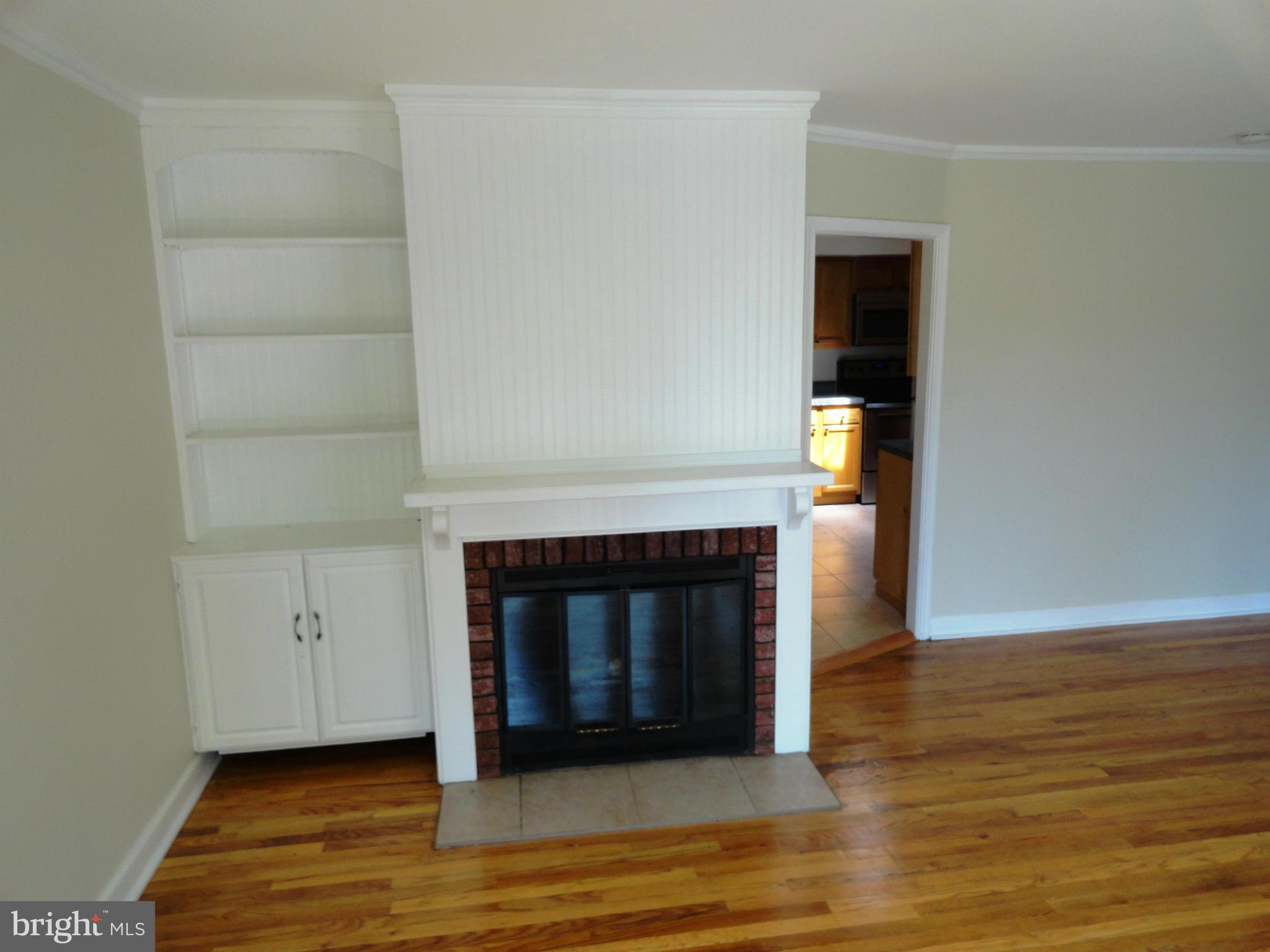 1614 Weyburn Road Baltimore, MD 21237 - Photo 6 of 25 a living room with a fireplace and a wooden floor