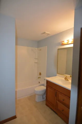 a bathroom with a sink a toilet and a large mirror