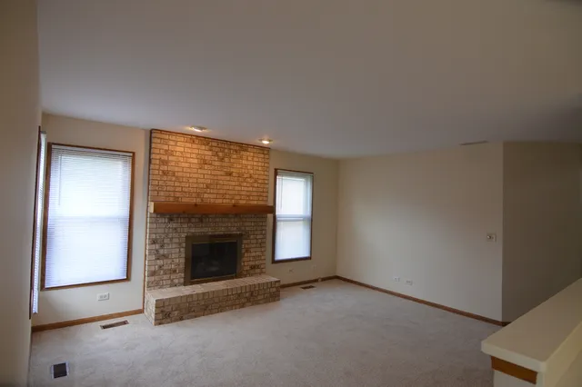 an empty room with a fireplace and window
