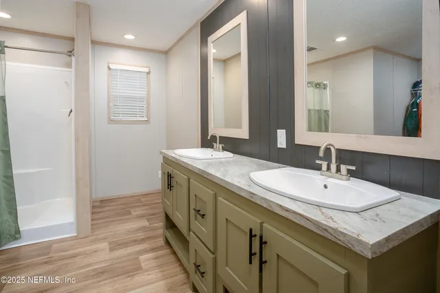 a en suite bathroom with a granite countertop sink and a mirror