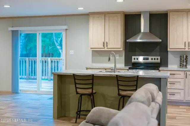 a kitchen with stainless steel appliances granite countertop a stove a sink and a refrigerator