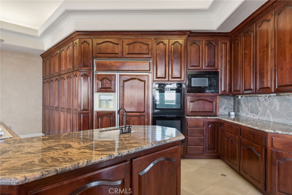 6872 Chartwell Drive Riverside, CA 92506 - Photo 33 of 75 a kitchen with stainless steel appliances wooden cabinets a sink and a stove