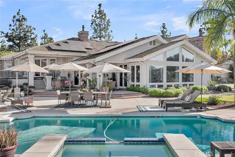 a view of a white house with a patio table and chairs