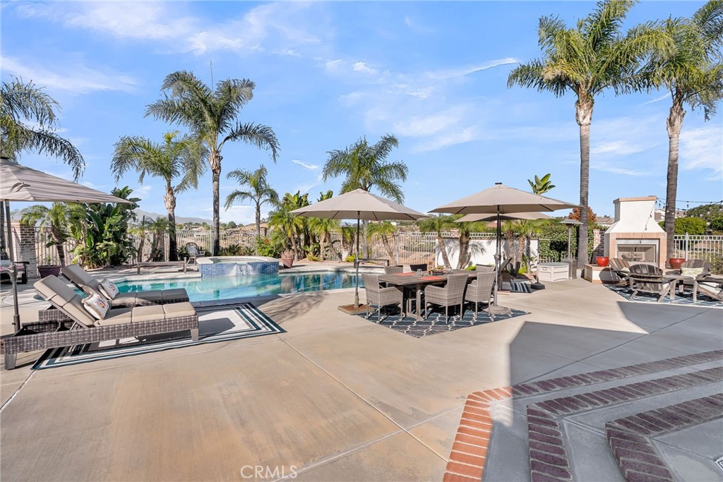 6872 Chartwell Drive Riverside, CA 92506 - Photo 37 of 51 a view of a patio with a table and chairs under an umbrella with potted plants