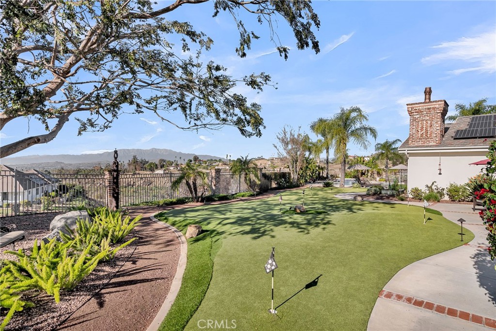 6872 Chartwell Drive Riverside, CA 92506 - Photo 43 of 51 a view of a swimming pool with a lawn chairs under an umbrella