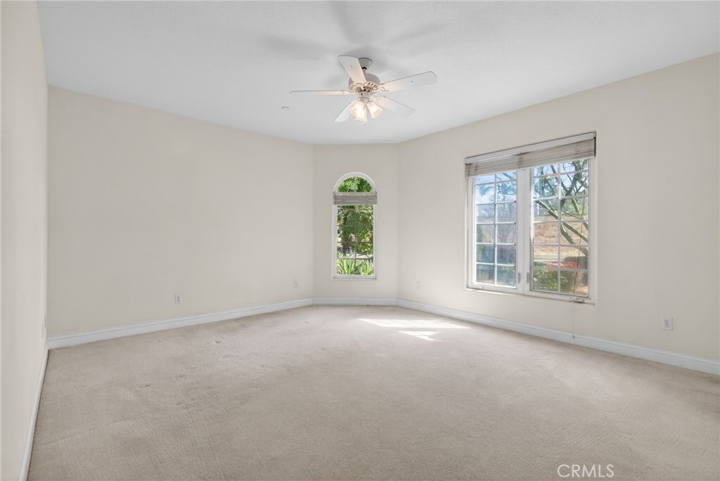 6872 Chartwell Drive Riverside, CA 92506 - Photo 47 of 75 an empty room with windows and chandelier fan